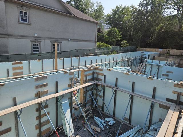 Braced ICF foundation tied in beside an existing stone house
