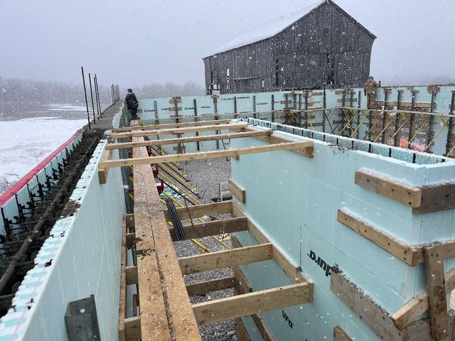 Floor assembly landing on ICF walls — joists hung and sheathing going down