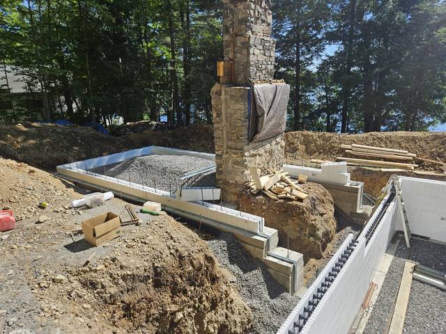 The fireplace standing free as the new structure begins