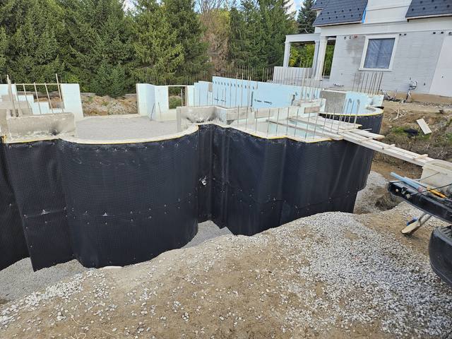Pebble Ridge — waterproofing on and interior stone in, ready for backfill