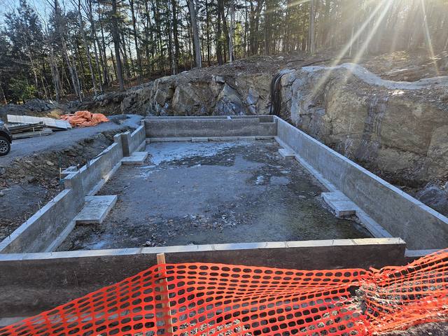 A cottage build — footings formed and poured straight onto the rock