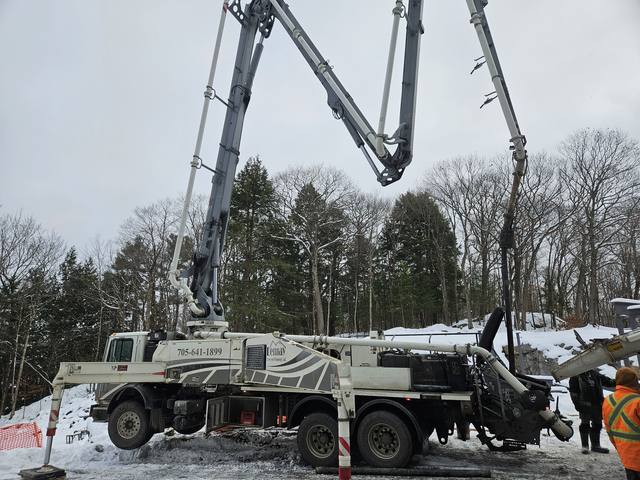 A cottage build — the pump truck set up for a winter pour in the bush
